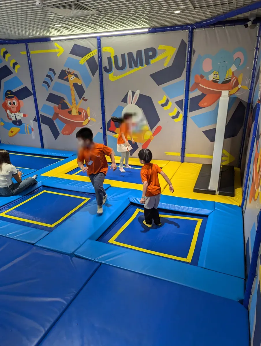 Children on the trampolines beneath the 'JUMP' mural at Kiztopia, Jewel Changi.