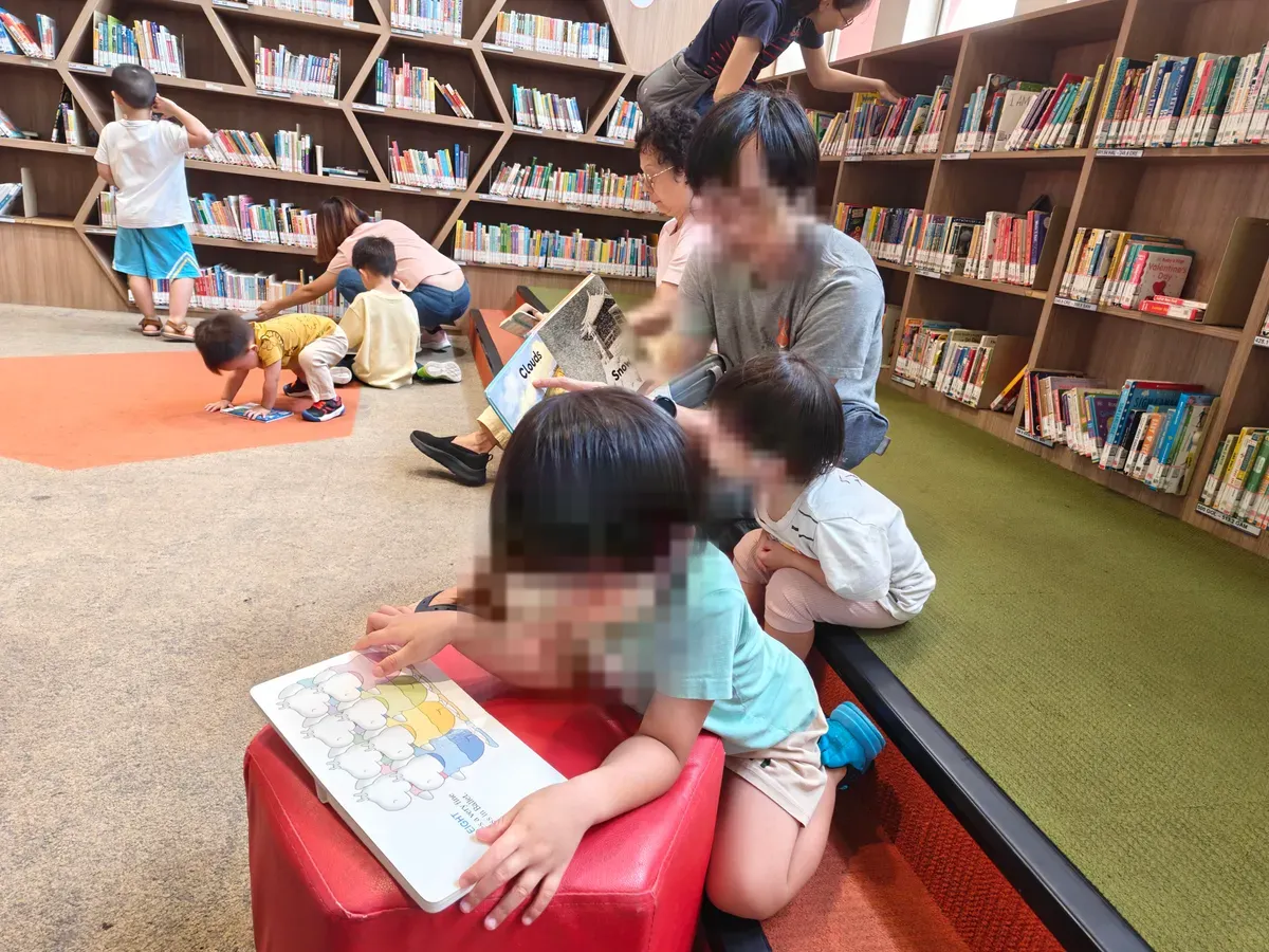 Young children reading picture books in the children’s section of Toa Payoh Public Library.